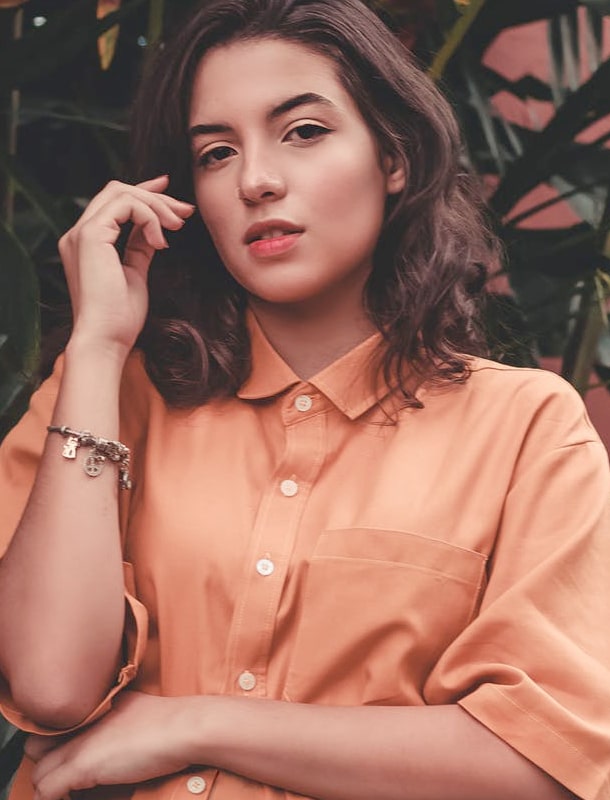 Girl in peach-coloured shirt wearing a bracelet