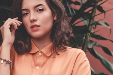 Girl in peach-coloured shirt wearing a bracelet